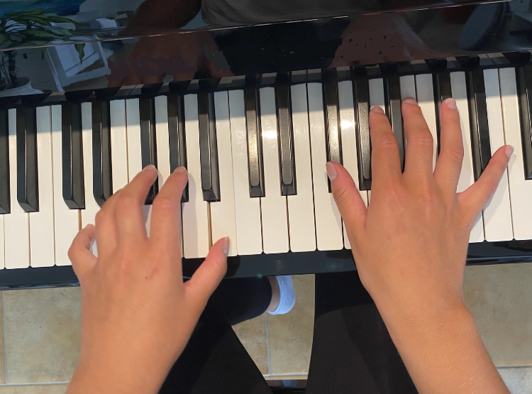 Hands on a piano keyboard